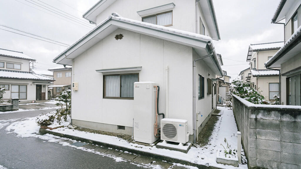 雪のある住宅でエコキュートの設置場所を考えるイメージ